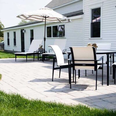 Backyard patio with a curved edge in a fenced backyard with outdoor dining setup.
