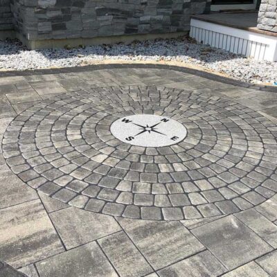 Hardscaped front patio with a custom compass design built into the stones by Willie C. & Sons Landscaping