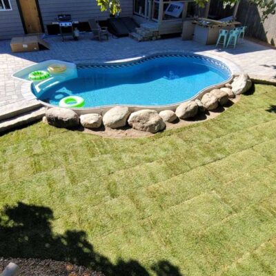 Stone patio and pool surround built for a residential backyard by Willie C. & Sons Landscaping.