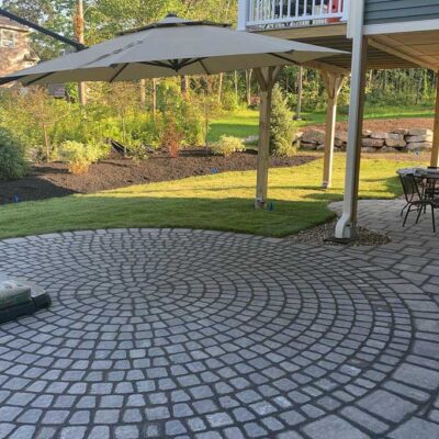 Custom stone patio by Willie C. & Sons in a Portland, Maine yard.
