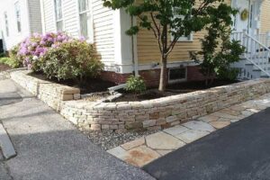 Tiered retaining wall for a flower garden built by Willie C. & Sons Landscaping for a home on a corner.